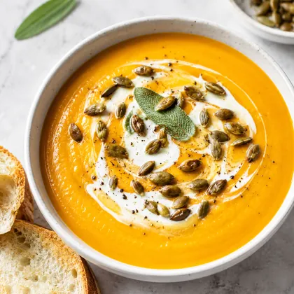 Prato fundo com creme de abóbora, sementes e um fio de creme por cima